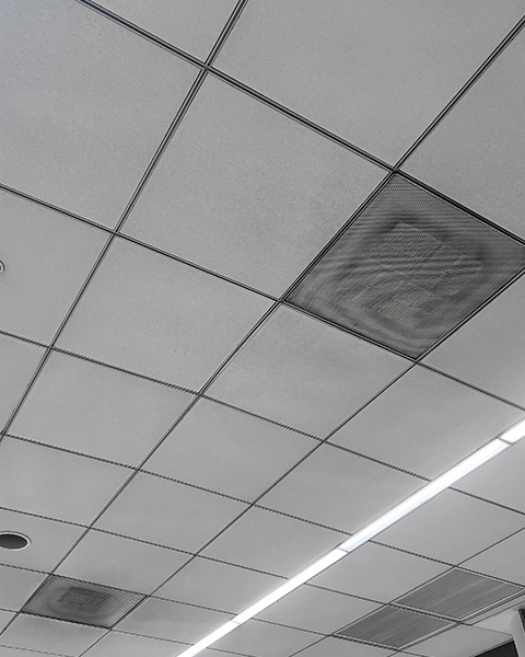 ceiling tiles with air vents and light strips showing signs of wear and tear maintenance required six ceiling panels visible